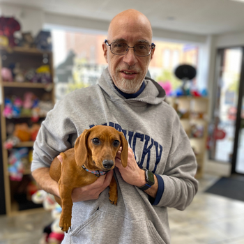 Andy holding his dog inside of Barkley's store